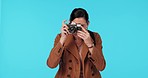 Photography, travel and woman with camera in studio on holiday, vacation and adventure on blue background. Tourism, creative and excited female person take picture for memories, blog and social media