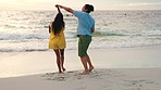 Happy couple, dance and beach by water for fun holiday, weekend or summer break together in nature. Man and woman holding hands and enjoying bonding time by the waves on the ocean coast outdoors