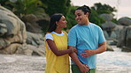 Love, date and a couple walking on the beach together for romance on their anniversary or valentines day. Travel, honeymoon or vacation with a young man and woman bonding by the ocean in nature