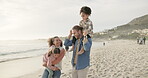 Piggyback, children and summer with a family at the beach, walking on sand together for travel or vacation. Mother, father and kids by the ocean for bonding while on holiday on the coast in nature