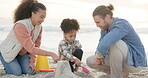 Family, playing and beach with toys for fun or bonding in outdoors with travel, interracial or happy. Kid, parents and quality time with ocean to enjoy together in outdoor for activity in summer.