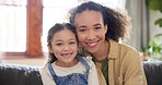 Love, face and mother with girl child on a sofa bond, happy and relax in their home together. Portrait, smile and cheerful parent with kid in a living room, embrace and sweet while enjoying weekend