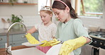 Cleaning dishes, water and children learning in kitchen with sister, girl or helping to wash, dry and clean house with soap. Kids, washing and plates, cutlery or teaching housework to girls in home