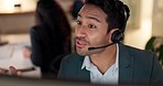 Face, call center and a man talking on a headset for customer service, advice or crm. Asian person working late at office for telecom, telemarketing or technical support and help desk consultation