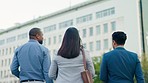 Business people in city together from back, conversation and morning commute to work with networking and diversity. Walking, corporate team and conversation, men and women outside office building.