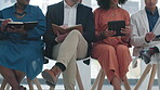 Tablet, notebook and human resources with job opportunity candidates waiting in line for an interview. Hiring, resume and documents with business people sitting in an office for company recruitment