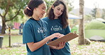 Summer, nature and women with a list for a camp, planning activities and schedule in the morning. Help, volunteer and young girls speaking about an agenda for a holiday or travel weekend in a park