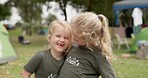 Family, hug and face of girl children camping a forest, fun and bonding on vacation outdoors. Love, kids and portrait of sisters hug, smile and happy in nature, playful and enjoy holiday in woods