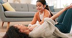 Children, love and a mother playing with her daughter on the living room floor of their home together. Family, playful or laughing with a woman and girl child joking or bonding in their house