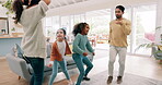 Parents, children and dance with a family in the living room of their home together for fun or bonding. Kids, funny or love with a playful mom, dad and sister siblings moving to music in their house