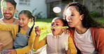 Children, garden and a family blowing bubbles together outdoor during summer for fun while bonding. Mom, dad and happy kids playing with a bubble wand in the backyard of their home during the day