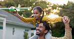 Daughter on father shoulders, airplane and toys outdoor, love and bonding outdoor, happiness and playing games at home. Man, girl and family, energy and playful with freedom in backyard and trust