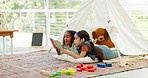 Learning, reading book and girls in tent, friends studying and knowledge in homeschool. Education, storytelling and children camping in house, bonding on floor and talking for development together.