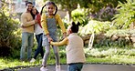 Happy, jumping and children on trampoline in a garden with parents watching with love. Fun, playing and girl kids holding hands with energy on a toy and bouncing with mother and father in a backyard