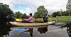 Kayaking, adventure and people rowing in the lake while on a vacation or weekend trip for travel. Nature, freedom and friends on a paddle boat on river for water sports on holiday in forest or woods.