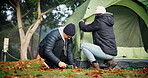 Couple, camp and preparing a tent outdoor in nature with teamwork, tools and adventure. A young man and woman camping together in winter for holiday, travel or vacation to relax at a forest campsite