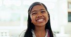 Happy, home and face of a girl child with youth, young and relax in the living room. Smile, cute and portrait of a little kid in a house with confidence, laughing or beautiful with a sweet expression