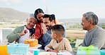 Communication, video call and big family at a birthday party celebration with a cake and presents. Happy, smile and people on virtual conversation with a phone to celebrate with man at outdoor event.