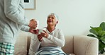 Senior couple, giving and drinking coffee on sofa in home living room for morning routine, relax and love. Smile, happy and tea cup for elderly man and talking woman with house blanket and bonding