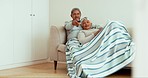 Senior couple, relax and watching tv on sofa with home living room blanket for love, movies and pointing at show. Smile, woman or happy elderly man with television remote for house streaming on couch