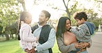 Nature, talking and parents walking with their children in an outdoor park for fresh air together. Happy, conversation and young mother and father bonding and laughing with their kids in green garden