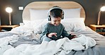 Boy, child and tablet with headphones in bedroom at night for online games, streaming movies and play educational app. Happy kid, digital technology and listening to media, watching cartoon and music