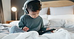 Boy, kid and tablet with headphones in bedroom for online games, watching movies and play educational app at night. Child, digital technology and listening to multimedia, music and streaming cartoon