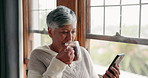 Reading, news and coffee with senior woman in home for communication with media or focus. Relax, cellphone and information for elder female with technology for ebook or conversation on online app.