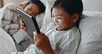 Tablet, night and a girl in bed with her mother, browsing social media or playing online games at home. Children, technology or video entertainment with a happy female child streaming in the bedroom