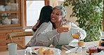 Hug, women and breakfast cheers in a family home with orange juice at table for health and wellness. A mother, people or friends together in dining room with love, care and conversation about food