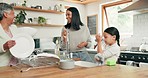 Child cleaning the kitchen with her grandmother and mother while bonding, talking and laughing. Happy, smile and girl kid washing the dishes with her young mom and senior woman in their family home.