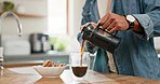 Hands, pouring coffee and breakfast in home kitchen, energy and start morning with warm matcha at table. Man, filter kettle and french press plunger for fresh organic caffeine at house for hot drink