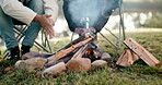 Campfire, warm hands and friends outdoor for fun, adventure and travel in woods. Camping, couple or people together at wood fire or flame on camp site chair for holiday, freedom or nature closeup