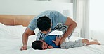 Play, father and son with love, bed and fun with happiness, quality time and energy on a weekend break. Male parent, boy and dad with kid, bedroom and relax with humor, home and carefree on vacation