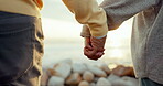 Couple, love and holding hands at the beach for care, commitment or adventure outdoor. Closeup of man and woman together for freedom, peace or support on holiday, travel or sunset vacation with trust