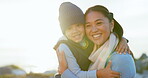 Sunshine, mother and son hug in portrait, love and care at beach, travel and happiness in nature. Cold weather, winter and family, woman and young boy with smile, trust and safety with weekend trip