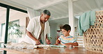 Family, laundry and a grandfather teaching his grandchild how to fold clothes in the home for spring cleaning. Help, growth or education with a young boy child and senior man inside for chores