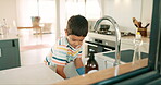 House, washing dishes or kid with gloves or dirty plates in kitchen sink at home for healthy hygiene. Learning independence, child development or boy cleaning to disinfect or prevent bacteria germs 