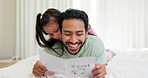 Father, child and reading a card in a family home on a bed for fathers day, love and art on paper. Man and girl kid in bedroom together with message, development and love for birthday or celebration
