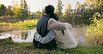 Travel, hug and couple by lake on mountain for bonding, quality time and relax in nature. Camping, wellness and back of man and woman embrace on vacation, holiday and adventure in forest or woods