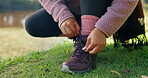 Hiking, fitness and shoes of person in nature for start, adventure and travel vacation. Holiday, trekking and camping with closeup of woman tying laces in park for camper, wellness and journey