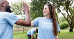 Happy woman, volunteer and high five for community service, teamwork or NGO in nature outdoors. Diversity, people or group touching hands in success or support for mission and cleaning park together