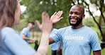 Happy black man, volunteer and high five for community service, teamwork or NGO in nature. Diversity, people or group touching hands in team success or support for mission and cleaning park together