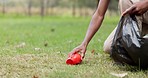 Man, hands and volunteer with bag for community service, recycling or cleaning pollution and waste on grass. Closeup of male person picking up dirt, rubbish or plastic for eco environment in nature