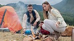 Couple, camping and fire with wood, smoke and relax together in mountains, nature and kettle on holiday. Man, woman and flames on ground for heat, cooking and vacation for coffee, field and outdoor