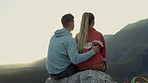 Hiking, view of mountain and couple relax on outdoor adventure with freedom in nature from back. Trekking, rock climbing and love, man hugging woman at sunset with backpack and motivation to travel.