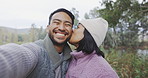 Couple, hiking in nature and selfie of kiss or camping, adventure or happy travel on social media or bonding together outdoor. People, happy face and peace on holiday, journey or mountain hike