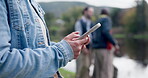 Camping, hands and phone with a person in nature, browsing social media on a blurred background. Hiking, mobile and communication with people in a forest or woods for travel and wilderness adventure