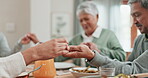 Family, people and holding hands for praying on food at dinner table at home. Closeup of group in worship, prayer or thanks for eating lunch meal, respect or gratitude in dining room at thanksgiving