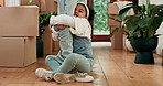 Child holding the leg of her father at their home while walking in the living room moving in. Cardboard boxes, naughty and dad dragging his girl kid for playing or bonding in their family house.